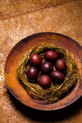 Beautiful red Easter eggs in a nest of straw on a large plate