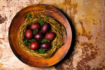 Easter eggs in a nest of straw on a large plate