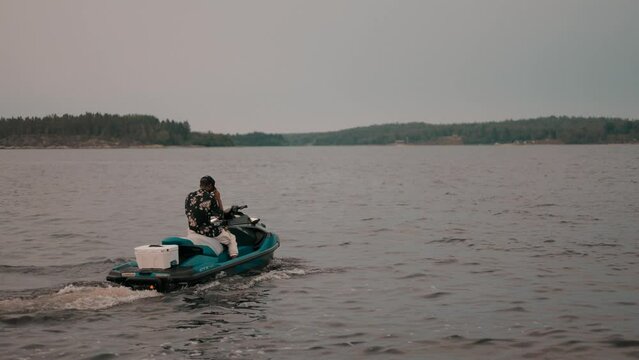 Guys riding jet skis on blue water in Sweden.