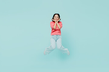 Fototapeta na wymiar Full body young smiling fun happy woman of Asian ethnicity 20s wearing pink sweater jumpo high hold face isolated on pastel plain light blue color background studio portrait. People lifestyle concept.