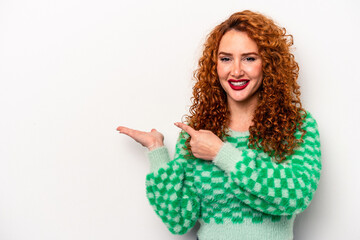 Young ginger caucasian woman isolated on white background excited holding a copy space on palm.