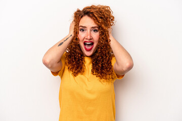 Young ginger caucasian woman isolated on white background screaming, very excited, passionate, satisfied with something.