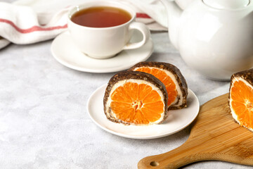Sweet chocolate roll with tangerine filling and a cup of tea.