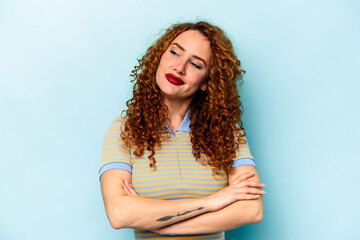 Young ginger caucasian woman isolated on blue background dreaming of achieving goals and purposes