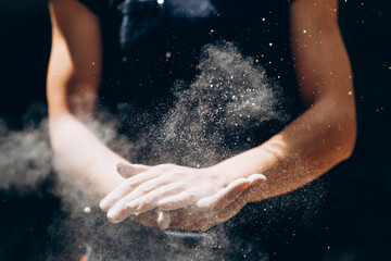 Female hands with magnesia powder close-up against the background of the mountains on a sunny day, the hands of a climber who prepares for outdoor training, a man is engaged in active sports