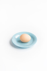 Light beige boiled egg on a plate. Blue small plate.