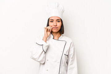 Young hispanic chef woman isolated on white background with fingers on lips keeping a secret.
