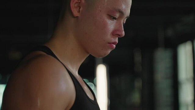  Young handsome Chinese man standing and sweating after exercise