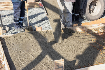 Pouring cement or concrete with a concrete mixer truck, construction site with a reinforced...
