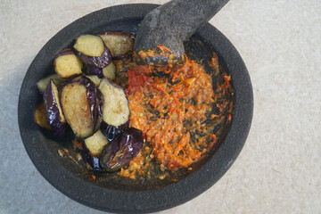 Slices of fried eggplant and chili sauce on a mortar. Focus selected