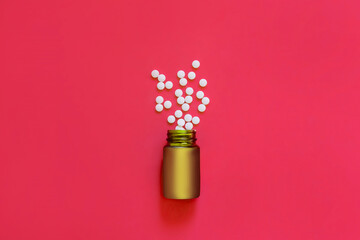 Assorted pharmaceutical medicine pills, tablets and capsules and bottle on red background. Copy space for text