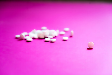 Assorted pharmaceutical medicine pills, tablets and capsules and bottle on pink background. Copy space for text