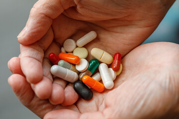 close-up female adult hands holding a lot of pills