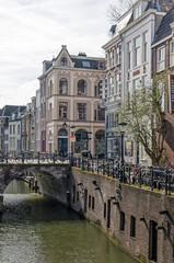 Utrecht, The Netherlands, March 13, 2022: picturesque scene in the heart of the old town with historic houses and a bridge across the Oude Gracht (Old Canal)