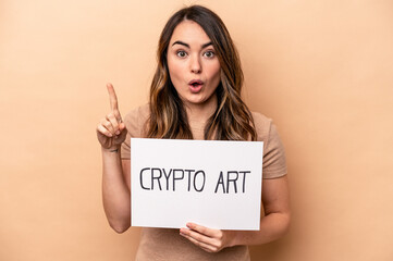 Fototapeta na wymiar Young caucasian woman holding a crypto art placard isolated on beige background having some great idea, concept of creativity.