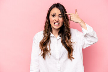 Young caucasian woman isolated on pink background showing a disappointment gesture with forefinger.