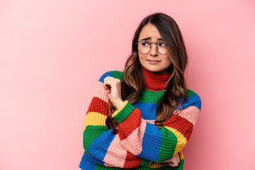 Young caucasian woman isolated on pink background confused, feels doubtful and unsure.