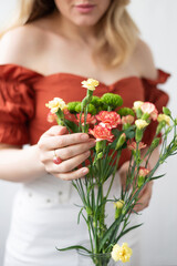 Bouquet of flowers in female hands. Beautiful chrysanthemum flowers bouquet in glass vase. Fresh cut flowers for decoration home. Making compositions and bouquets of flowers