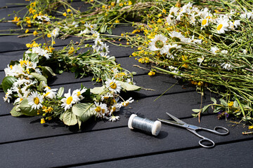Creating traditional Swedish Midsummer flower crown using wild summer flowers, scissor and wire.  - obrazy, fototapety, plakaty
