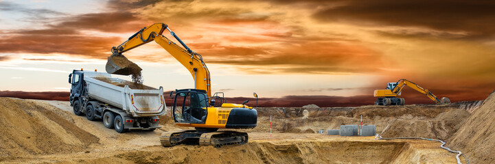 earth mover and excavator at work in construction site - obrazy, fototapety, plakaty