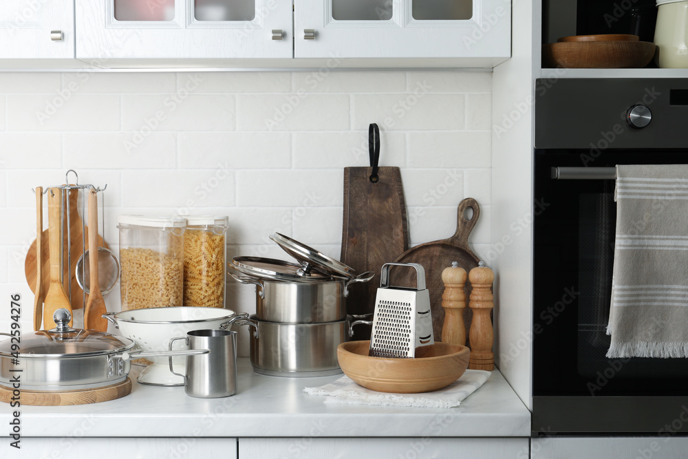 Poster Different cooking utensils and raw pasta on countertop in kitchen