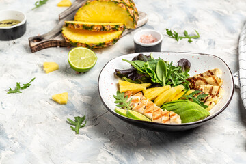 Assorted salad bowl lunch with grilled chicken, halloumi, avocado, green rocket salad, lime, sesame...
