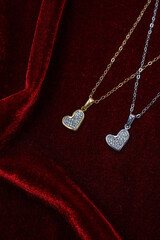 Collane d'argento e d'oro con ciondoli d'argento e d'oro a forma di cuore con diamantini...