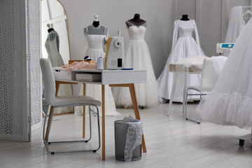 Fototapeta na wymiar Dressmaking workshop interior with wedding dresses and equipment