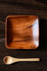空っぽでシンプルな木製の角皿とスプーン