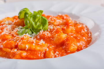 Piatto di gnocchi alla Sorrentino con sugo di pomodoro, mozzarella filante, formaggio grattugiato e basilico fresco servito in un ristorante elegante