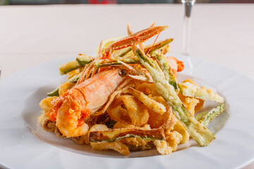 Fritto di pesce con scampi, gamberi, polipi, anelli di calamaro e verdure servito in un ristorante...