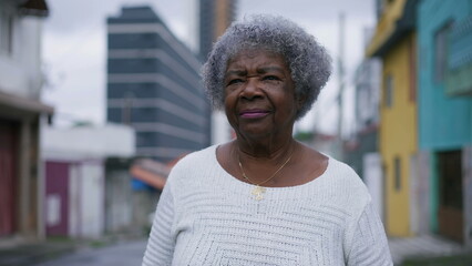 A senior black woman walking forward in urban street