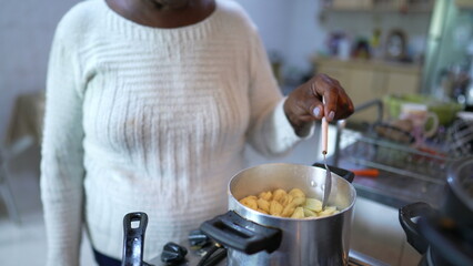 A Brazilian older person cooking at home a senior black woman preparing food