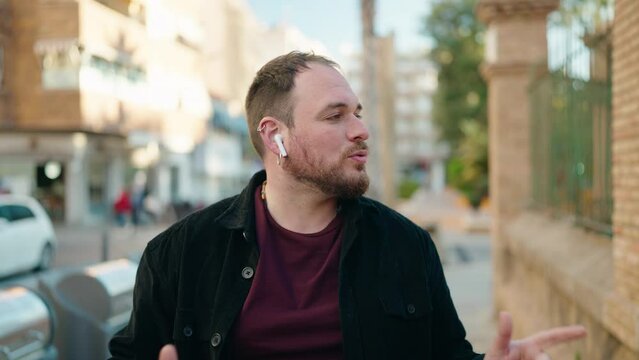 Young plus size man listening to music and dancing at street
