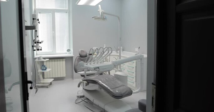 entry into the room bright modern dental office interior equipped with a modern full-functional dental unit of pneumatic type. Has a bottom supply of tools. Electromechanical chair of the patient