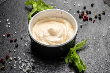 Bowl with garlic sauce on dark background. Food recipe background. Close up