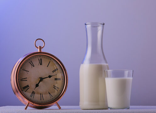 Morning glass of milk with an alarm clock.