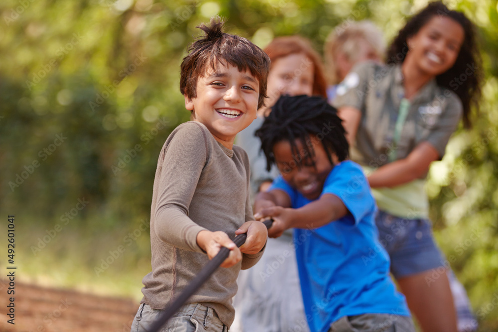 Poster learning teamwork through play. a group of kids in a tug-of-war game.