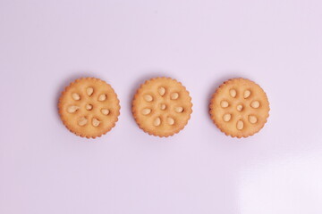 Selective focus of pile of peanut cookies and a piece of biscuit, white background front view