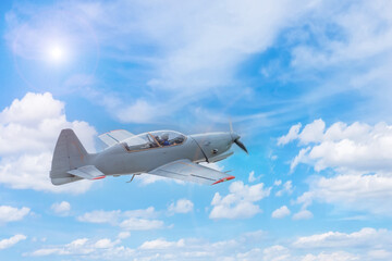 Fototapeta na wymiar Single-propeller aircraft flying over the blue sky.