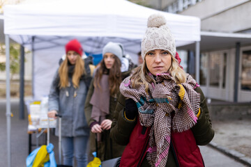 Depressed Ukrainian refugee woman crossing border and looking at camera.