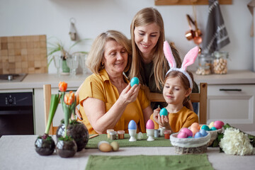 Happy easter family elderly grandmother and young woman mother blonde with little daughter with...
