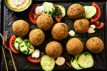Fototapeta na wymiar fried in oil falafel with cucumber-tomato salad and yoghurt with olive oil
