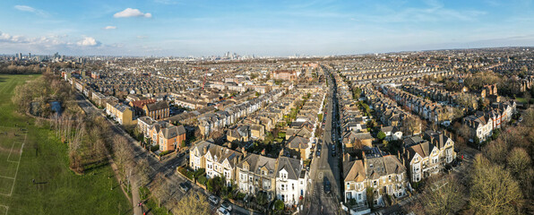 Panoramic aerial view of city of London skyline with terraced house rooftops of south west London in foreground 