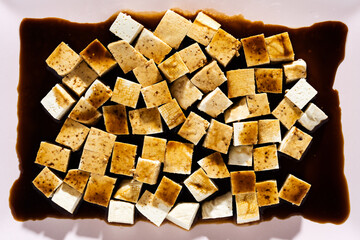 marinating tofu in soy sauce and sweet syrup. sesame