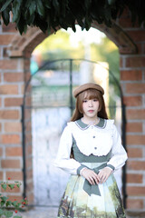 A beautiful woman in lolita dress in garden background Japanese street fashion portrait