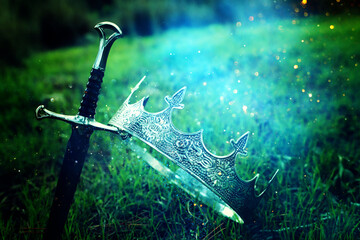 mysterious and magical photo of silver king crown and sword in the England woods. Medieval period...