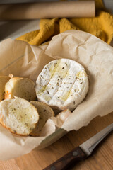 Camembert cheese baked in the oven with garlic sauce and spices. Homemade brie in the oven. Camembert with croutons in a baking dish