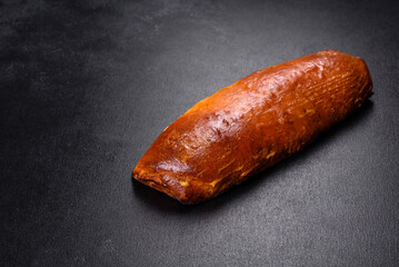 Delicious fresh roll with apricot jam on a dark concrete background