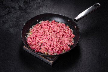 Fresh raw beef mince with onions in a pan